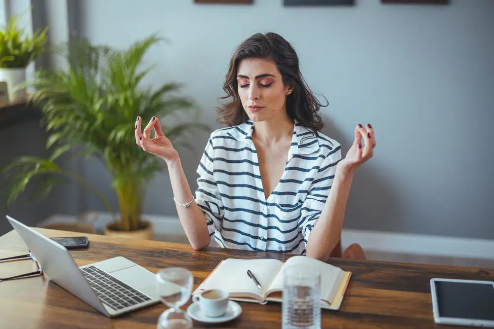Vivir para trabajar tiene nombre: esto es el Síndrome del Tupper Mujer meditando síndrome del tupper