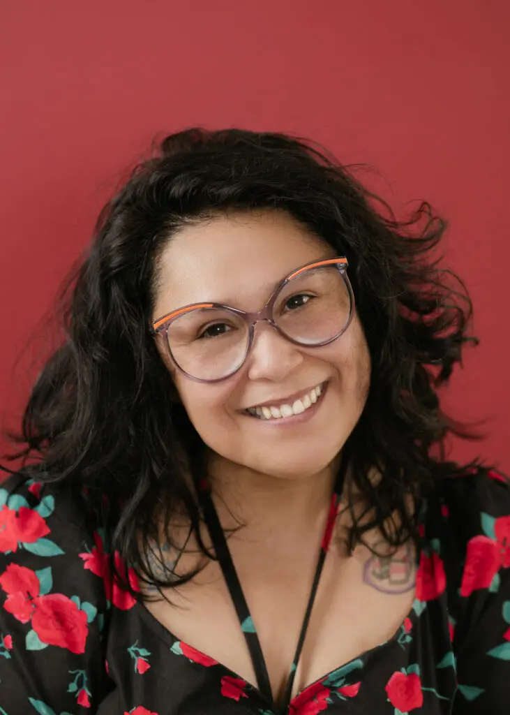 Elma correa sonriendo con una camisa negra con rosas