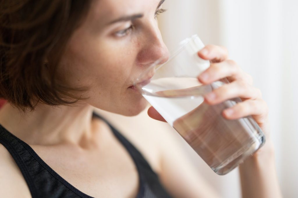 mujer tomando vaso con agua