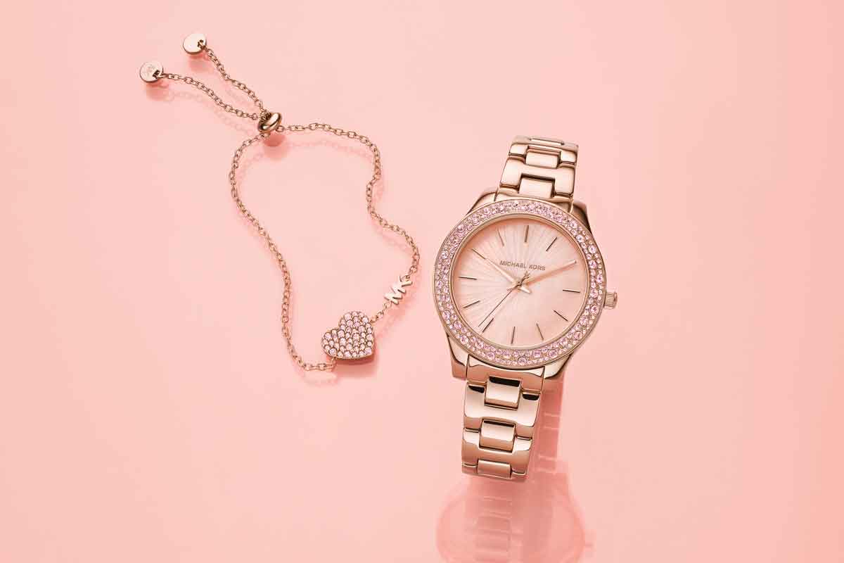 Set de pulsera corazón y reloj Michael Kors analógico, con tablero redondo y pulso en acero color rosa. Fotos cortesía Kevin's.