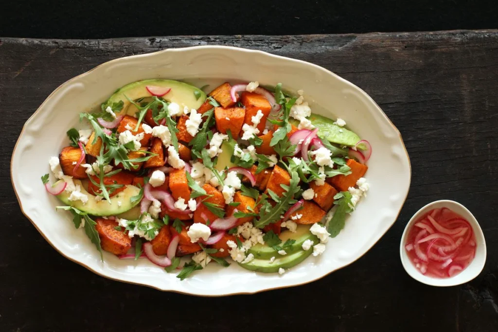 Receta de ensalada de batata asada con cebolla encurtida, aguacate y queso feta