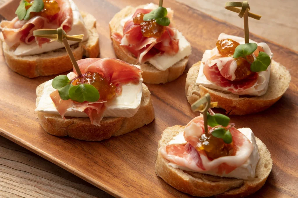 Antójese de montaditos de jamón con queso de cabra y compota de lulo