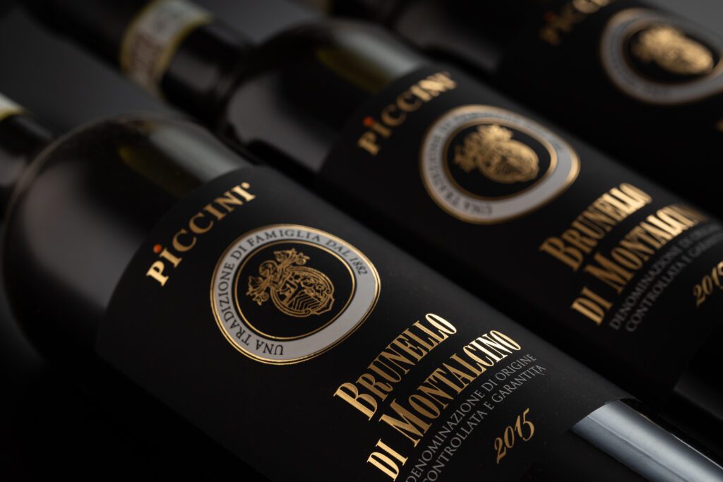 “colombia no es una apuesta, sino una historia que se extiende”, mario piccinni Botellas de vino de alta gama brunello di montalcino de piccini con etiquetas negras y letras doradas elegantes.