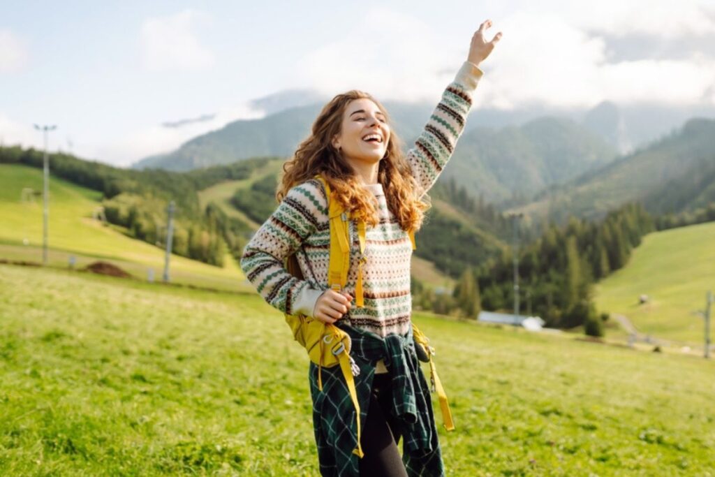 Mujer feliz de viaje en la montaña