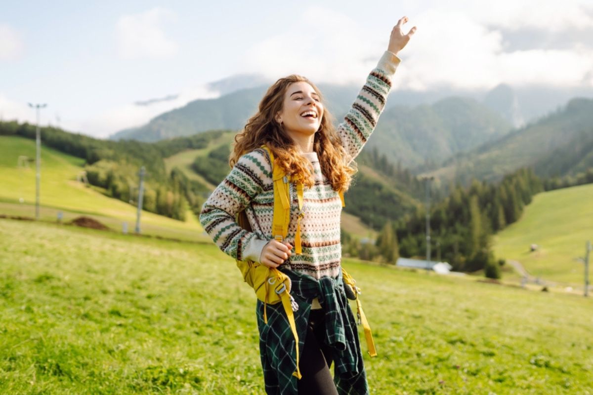 Mujer feliz de viaje en la montaña